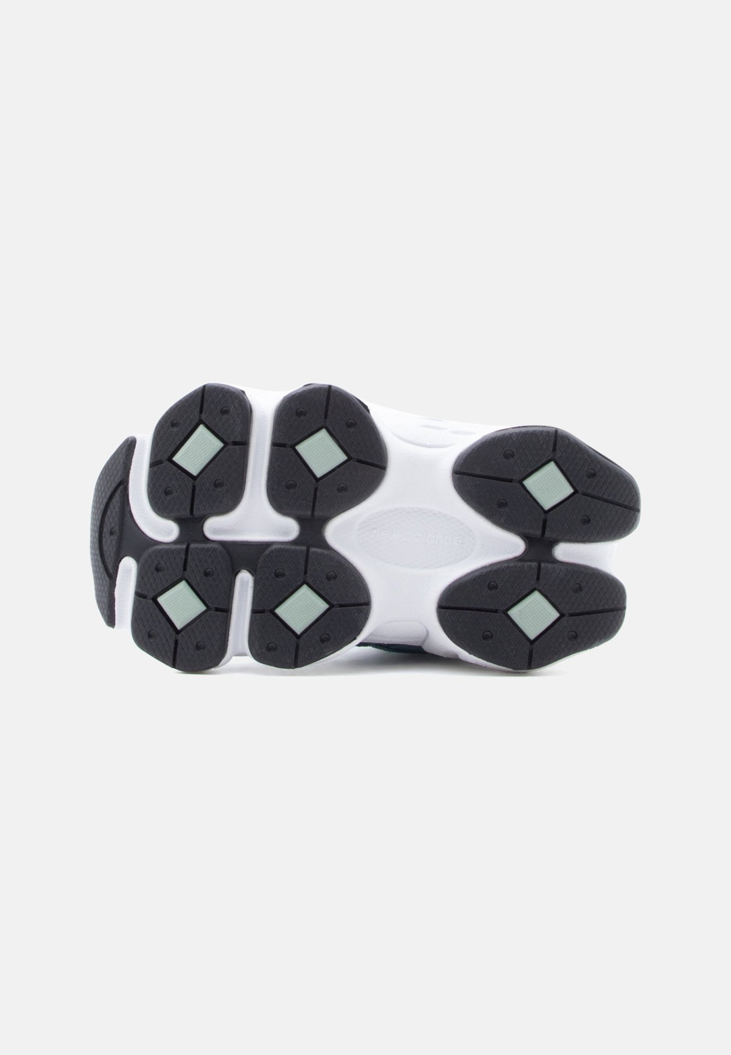 Suela de zapatilla blanca con suelas de goma segmentadas en negro y verde claro, diseñadas para agarre y flexibilidad.
