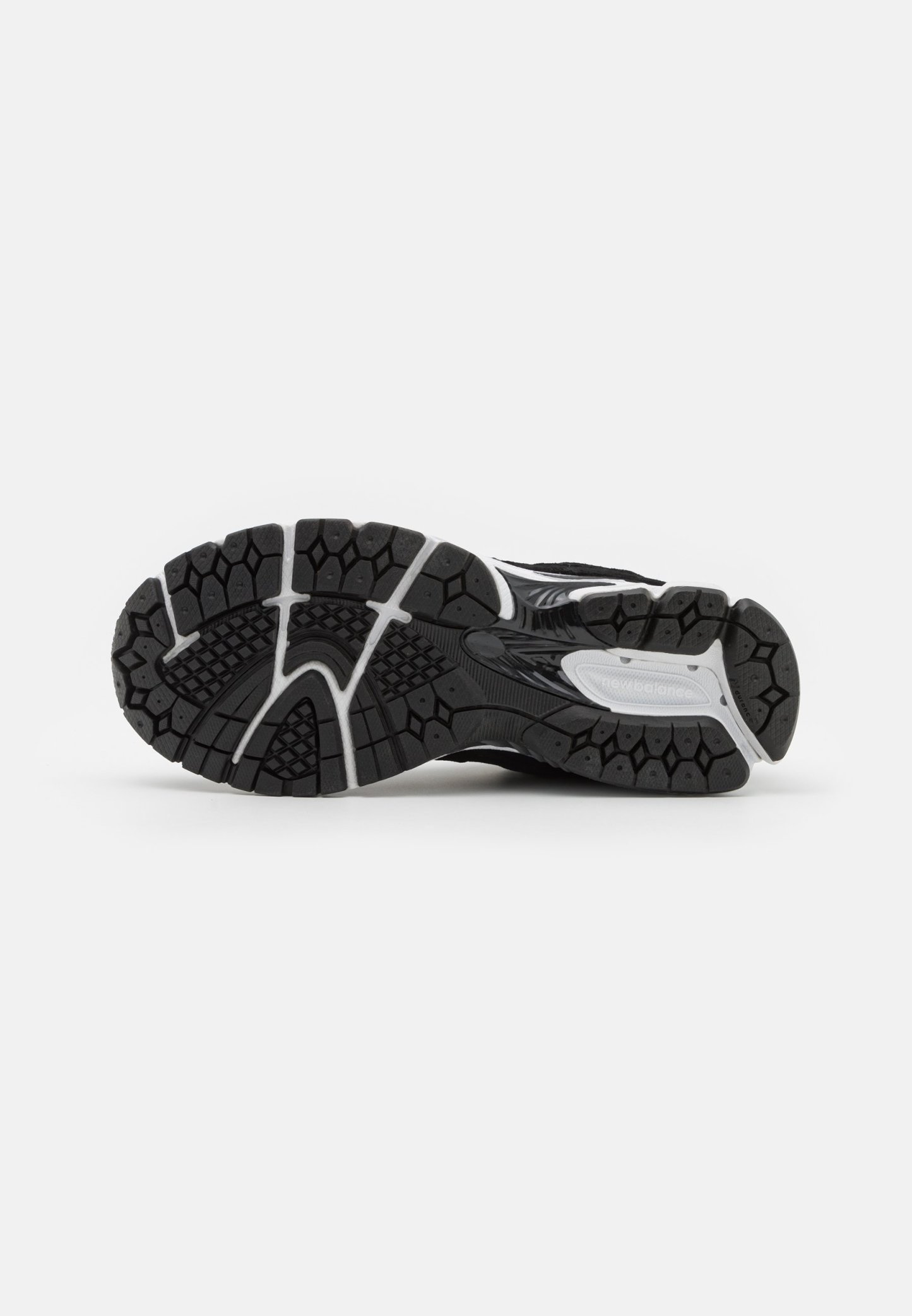 Suela de zapatilla atlética negra con un patrón texturizado, que presenta treads hexagonales para agarre y acentos grises alrededor de los laterales.