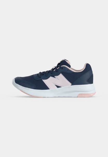 Zapatilla de running New Balance azul marino y rosa claro con parte superior de malla, cierre de cordones y suela acolchada blanca sobre un fondo liso.
