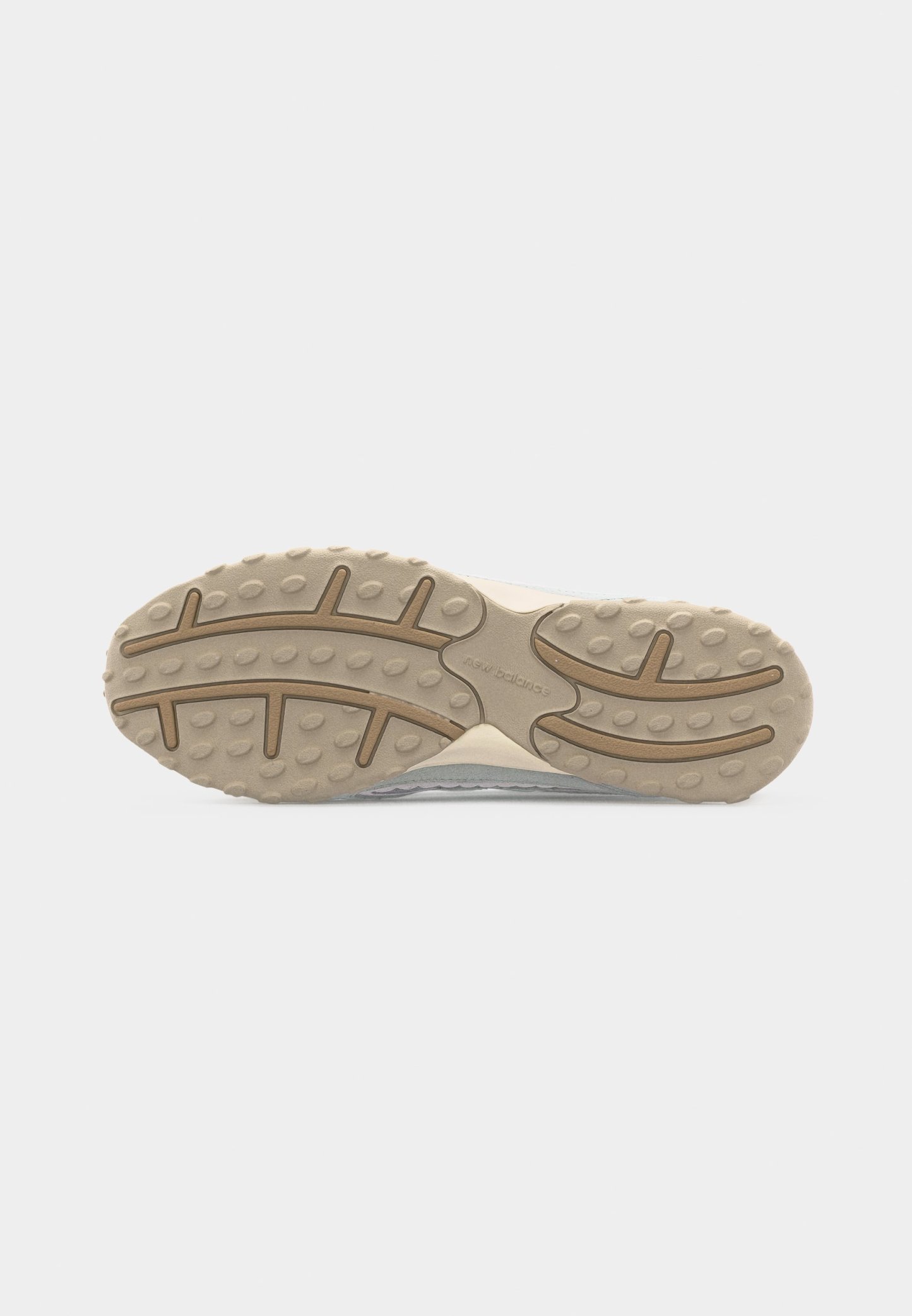 Suela de zapato con banda de rodadura de goma beige, tacos circulares de agarre, ranuras curvas y diseño central en zigzag sobre un fondo claro.