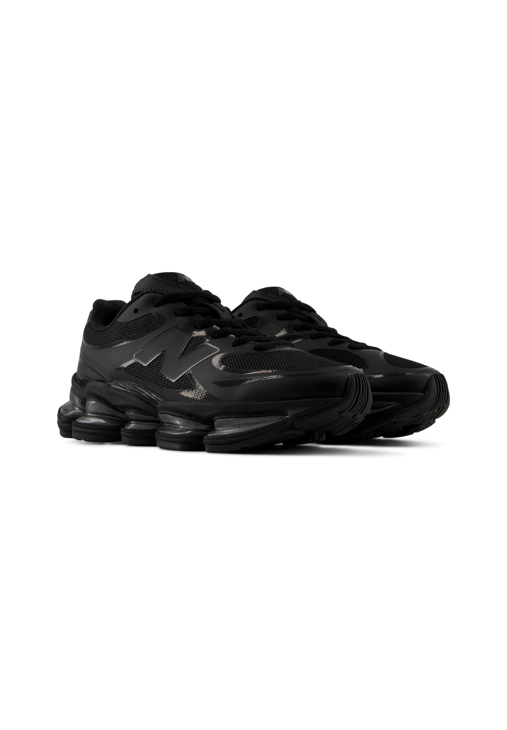 Par de zapatillas deportivas negras con suelas segmentadas gruesas y detalles de malla, con un logo "N" en el lateral.