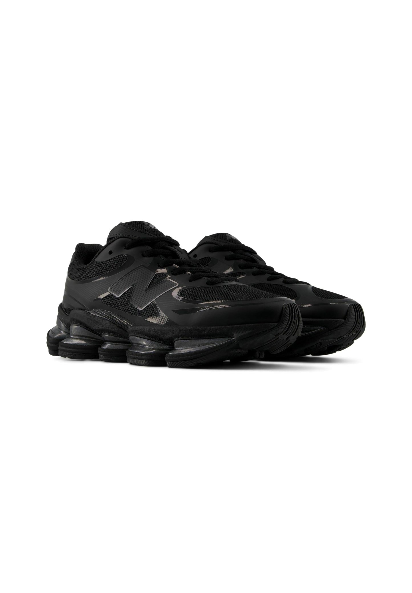 Par de zapatillas deportivas negras con suelas segmentadas gruesas y detalles de malla, con un logo "N" en el lateral.