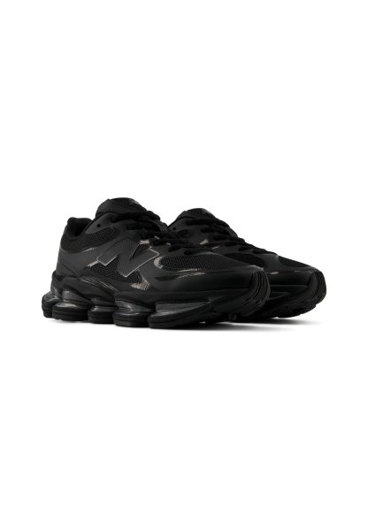 Par de zapatillas deportivas negras con suelas segmentadas gruesas y detalles de malla, con un logo "N" en el lateral.