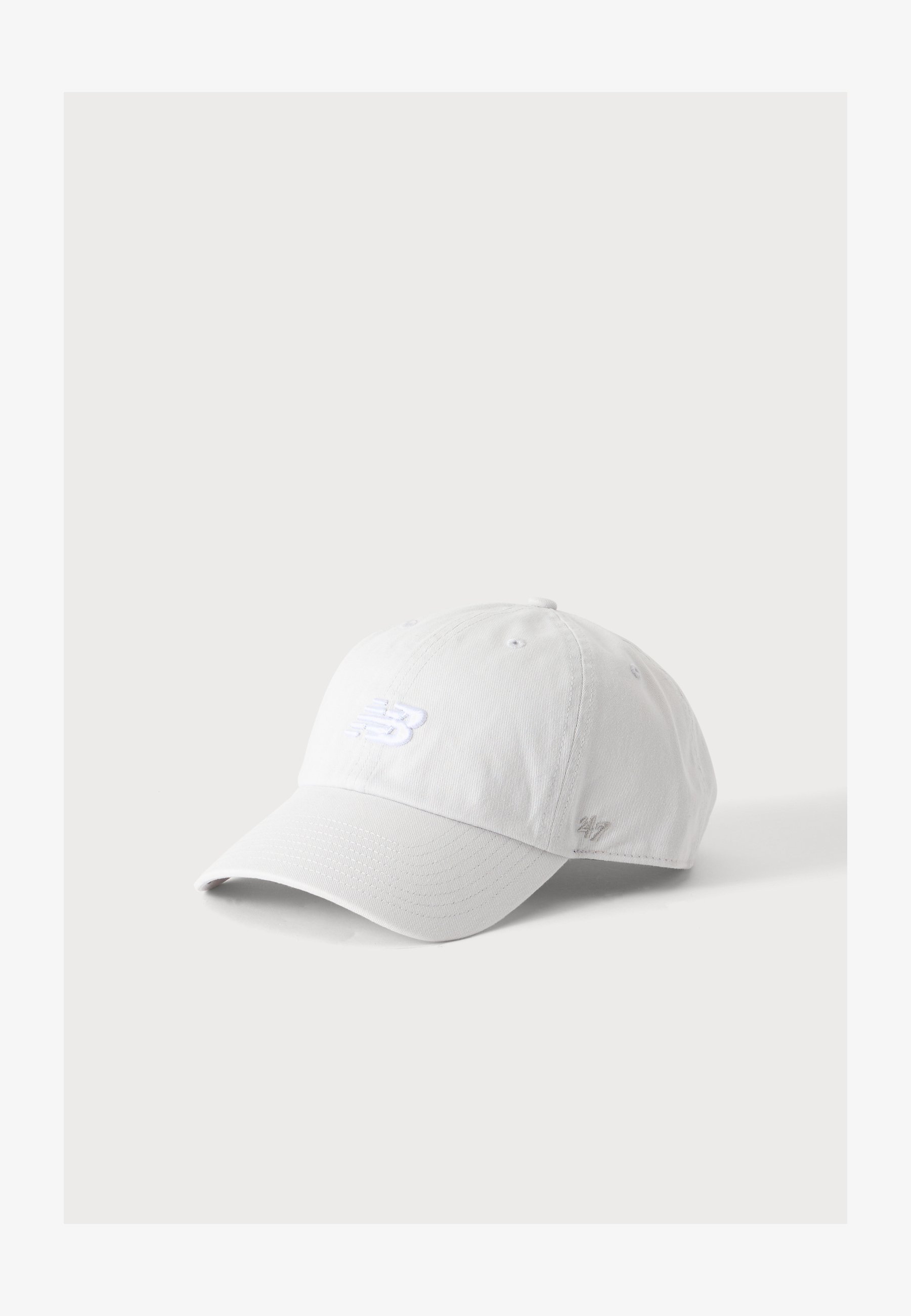 Gorra de béisbol blanca con visera curva, logo de New Balance bordado en el frente y un pequeño detalle '247' en el lateral.