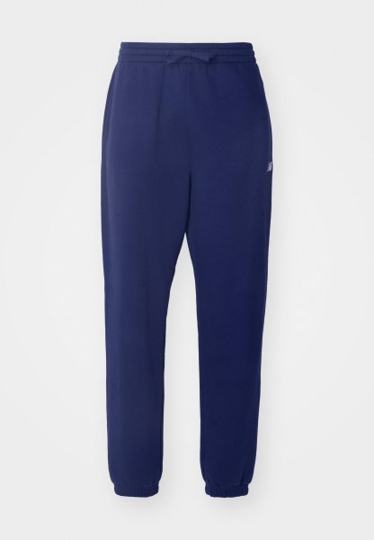 Joggers de color azul marino, con cintura elástica y cordón, piernas ajustadas y puños acanalados. Fabricados con una tela suave y con un branding mínimo.