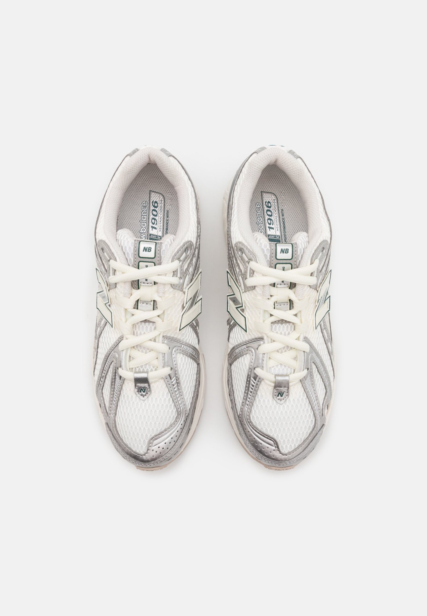 Zapatillas deportivas blancas de malla con detalles en plata. Las características incluyen cordones, una marca en la lengüeta y una suela acolchada. La parte superior tiene un diseño texturizado.