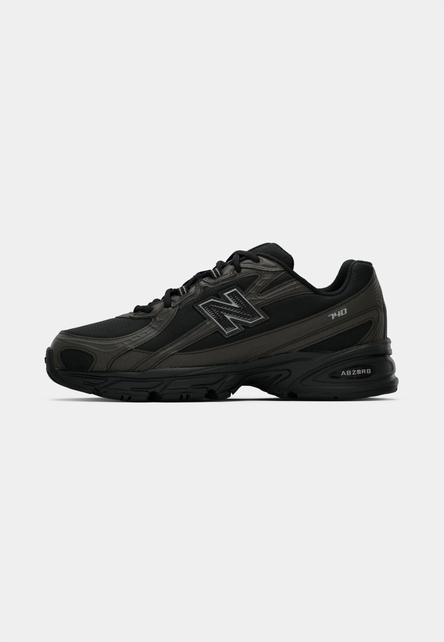 Zapatillas deportivas negras con un upper sintético texturizado, que cuentan con una suela acolchada y un prominente logo "N" en el lateral. El diseño incluye secciones de malla ligera.