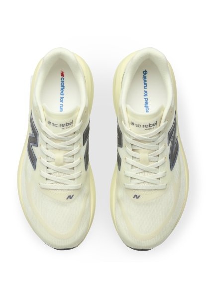 Par de zapatillas de running New Balance de color amarillo claro con logo gris y cordones blancos visto desde arriba sobre fondo blanco.