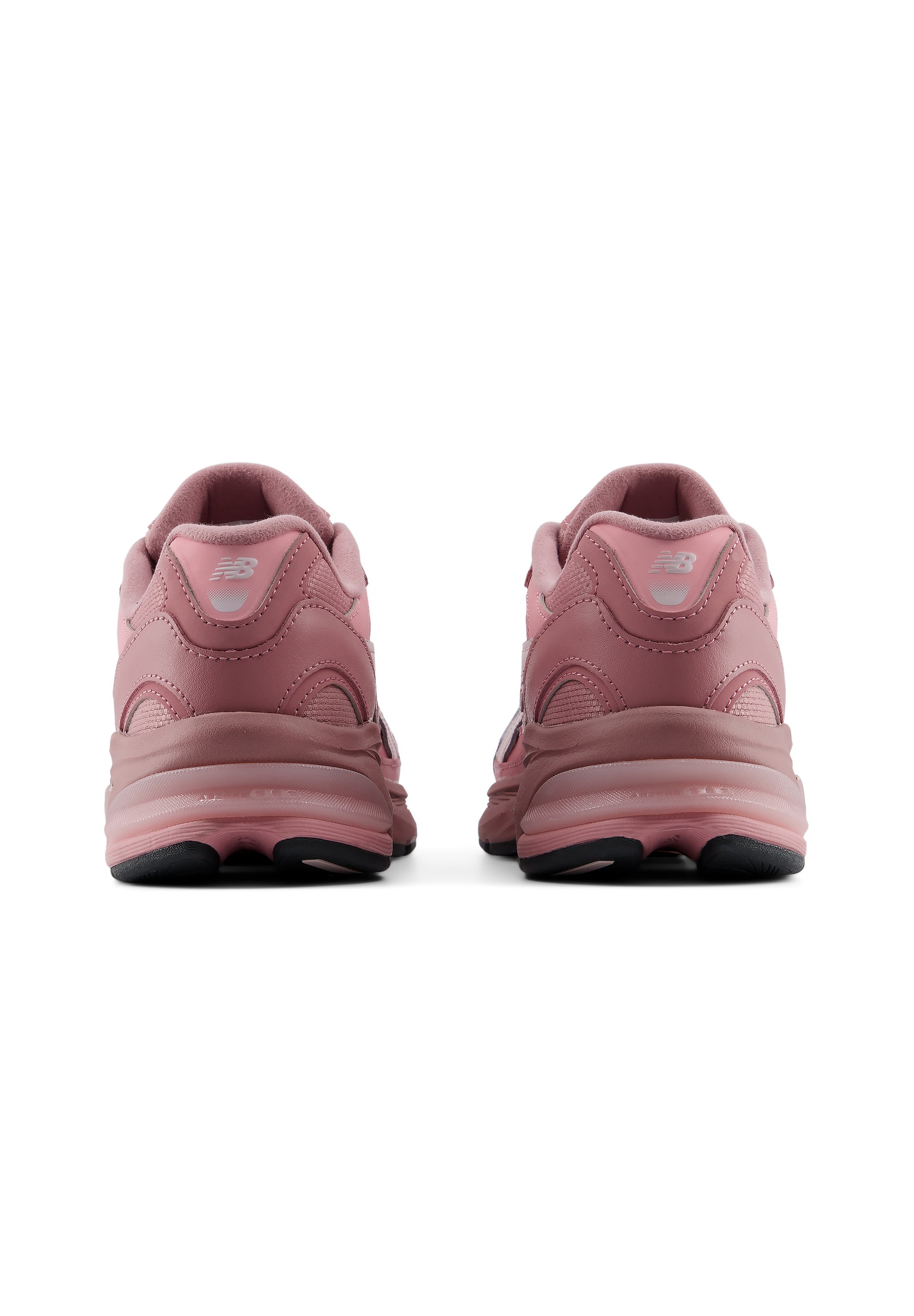 Par de zapatillas New Balance rosas vistas desde atrás con suelas gruesas y suela negra sobre fondo blanco.