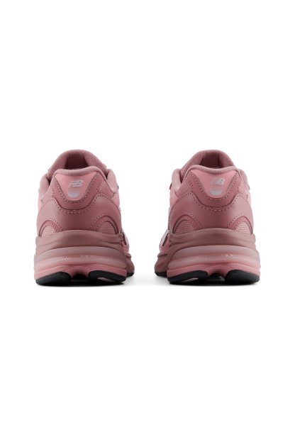 Par de zapatillas New Balance rosas vistas desde atrás con suelas gruesas y suela negra sobre fondo blanco.