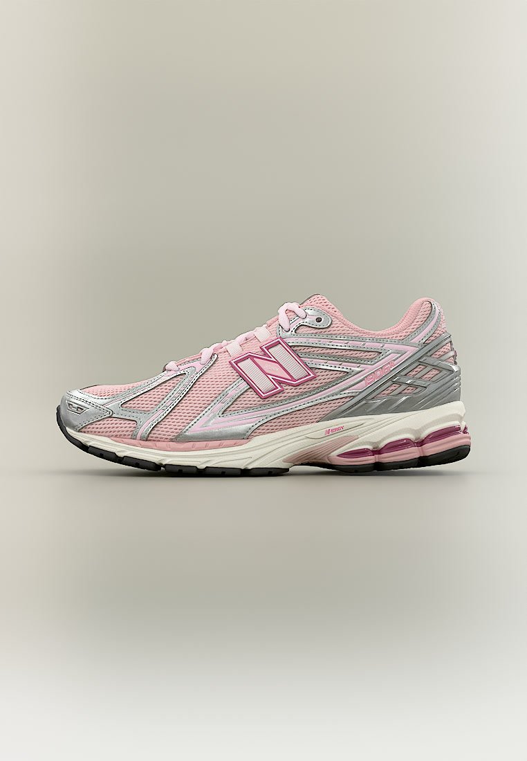 Zapatilla de running New Balance rosa claro con detalles en plata y blanco, parte superior de malla transpirable y suela acolchada con unidades de aire visibles.