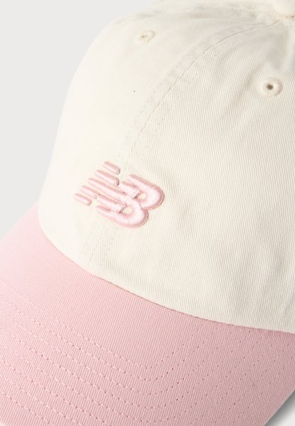 Gorra de béisbol con corona color crema y visera rosa que presenta un logo bordado en rosa en el panel frontal.