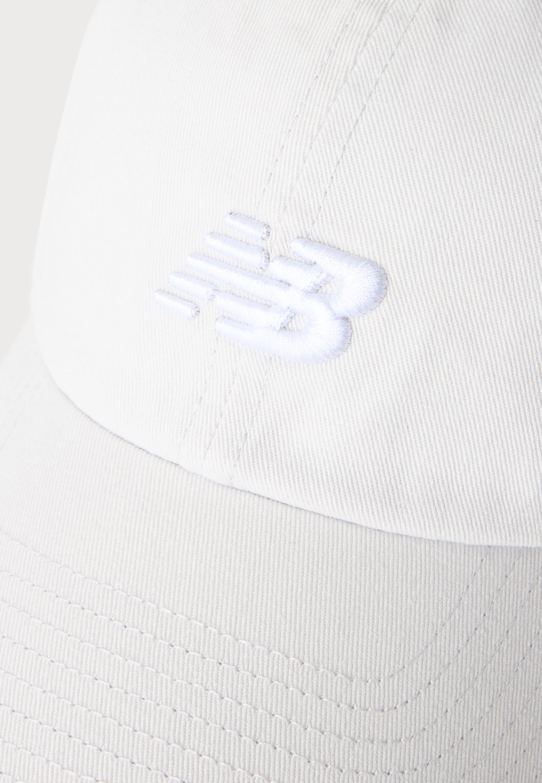 Gorra de béisbol blanca con logotipo bordado en blanco, texturizado y en relieve en el panel frontal.