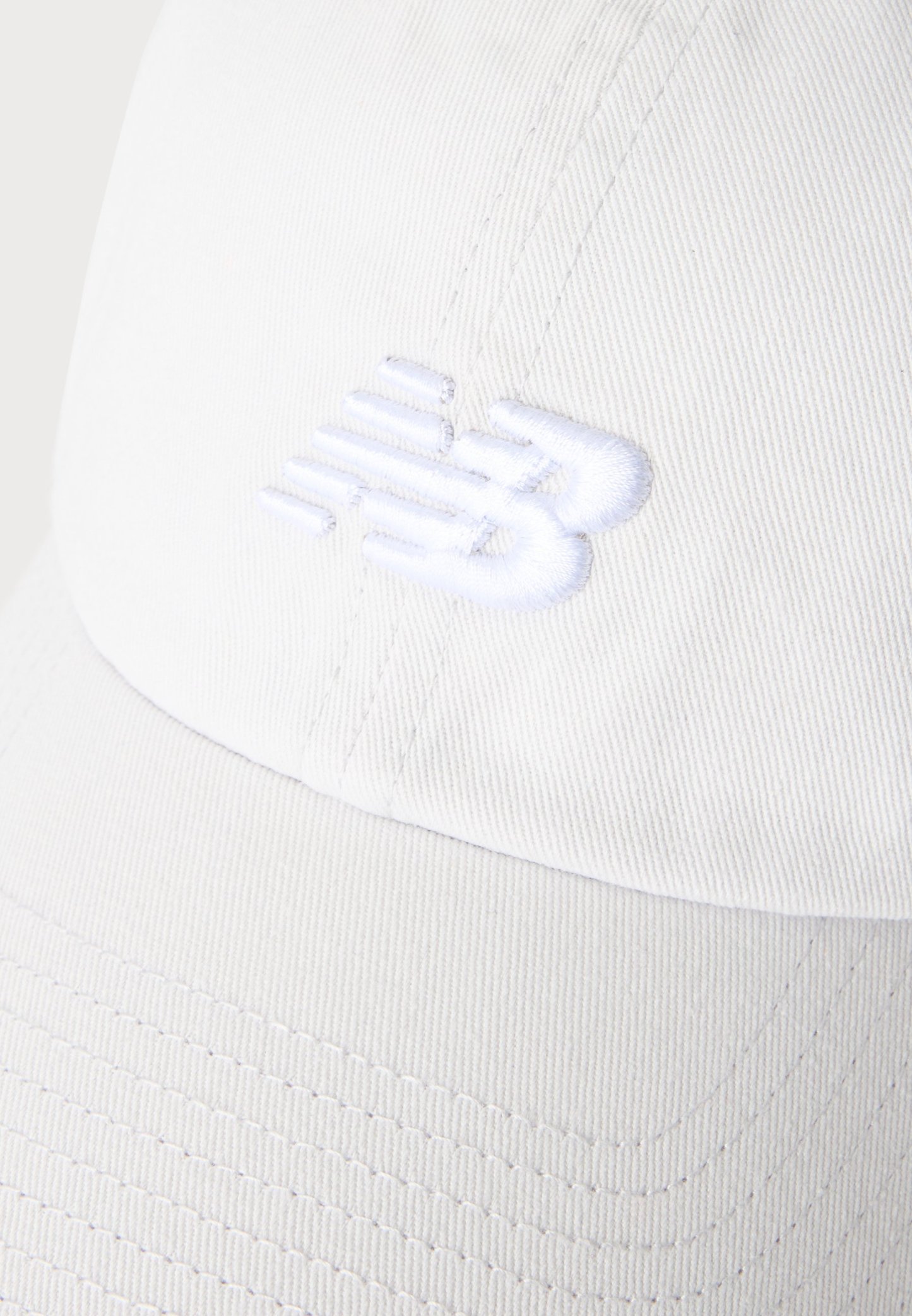 Gorra de béisbol blanca con logotipo bordado en blanco, texturizado y en relieve en el panel frontal.