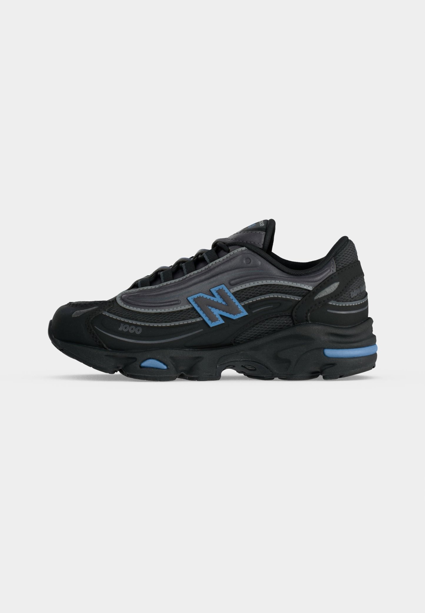 Zapatilla deportiva negra y gris oscuro con detalles en azul, diseño con cordones y un destacado logo "N" en el lateral.