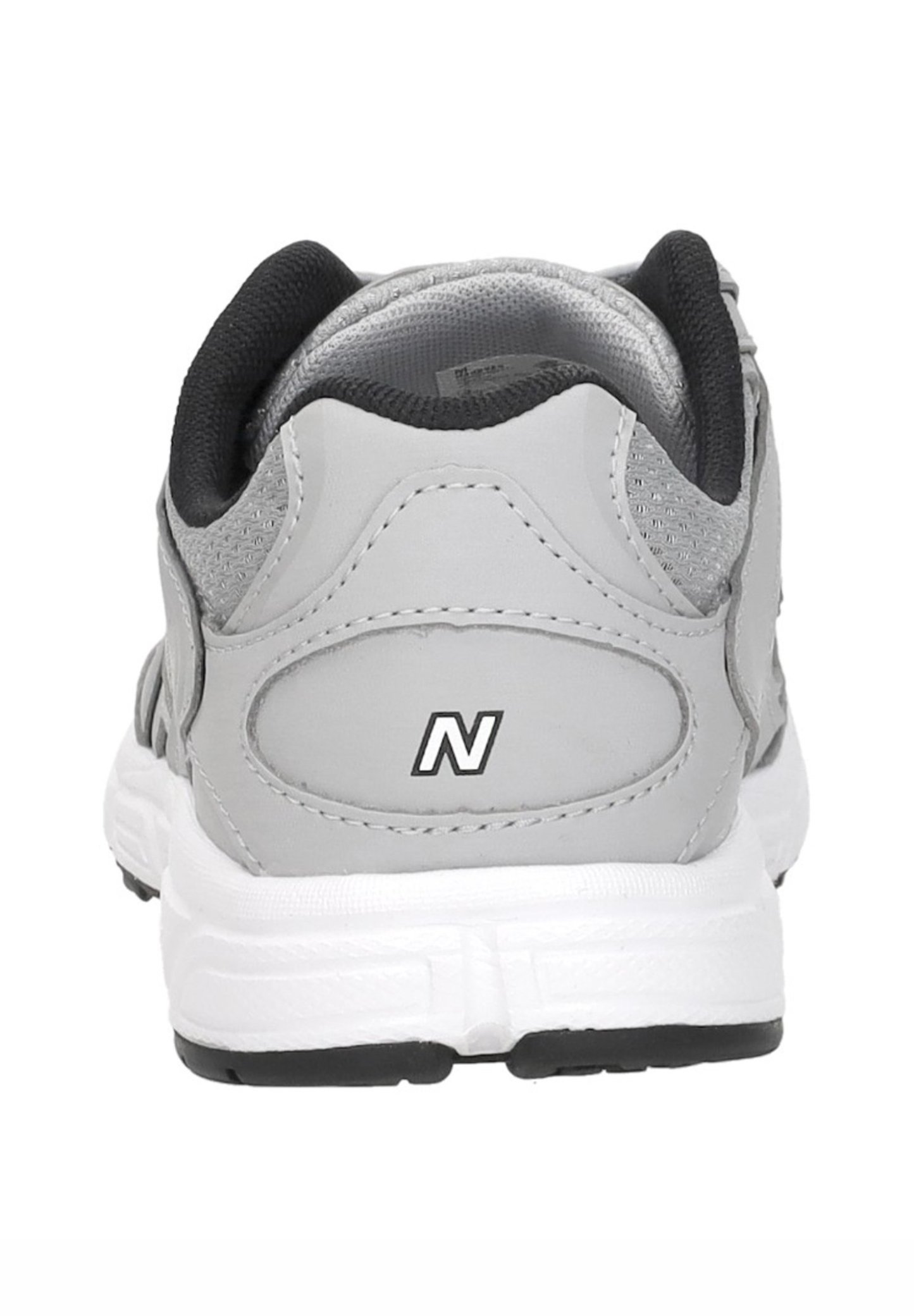 Zapatilla deportiva gris y blanca vista desde atrás, con forro de cuello negro y un logo "N" en el talón.