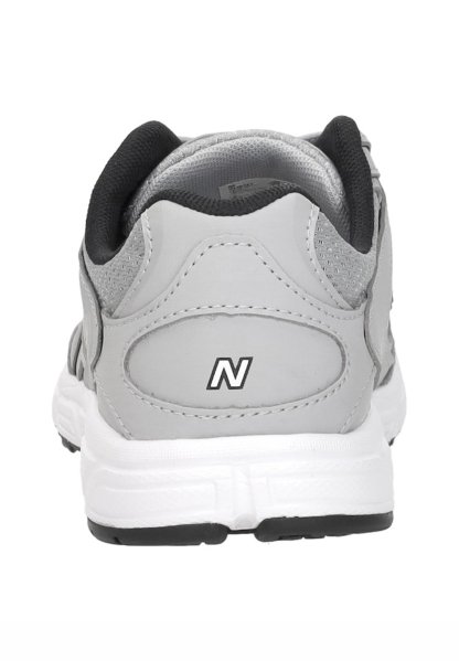 Zapatilla deportiva gris y blanca vista desde atrás, con forro de cuello negro y un logo "N" en el talón.