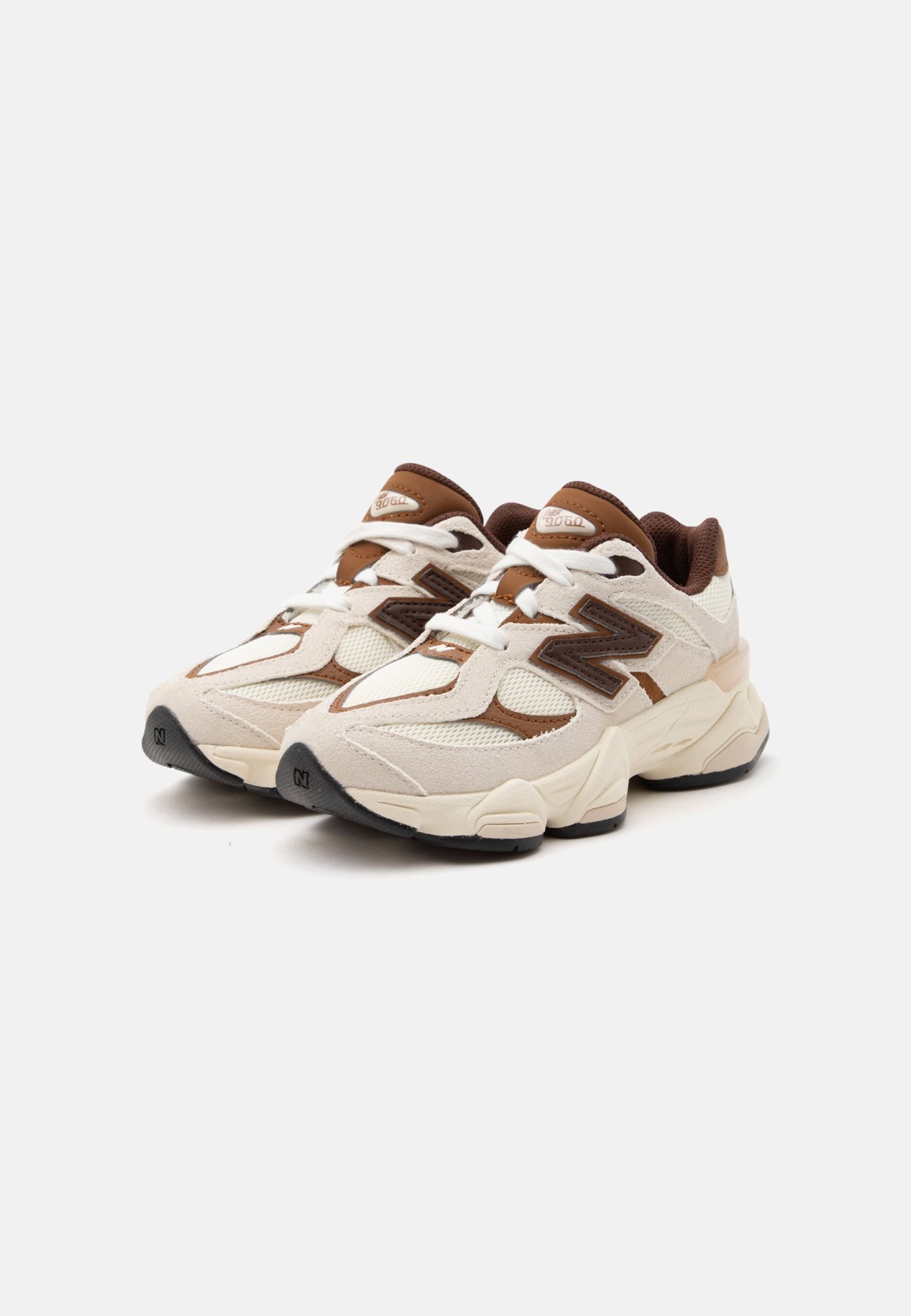 Par de zapatillas deportivas beige y marrones con cordones blancos y suelas gruesas, mostradas en un ligero ángulo sobre un fondo blanco.