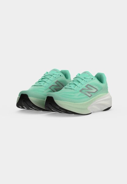 Par de zapatillas de running New Balance color verde menta con medias suelas blancas gruesas y suelas exteriores negras sobre un fondo blanco.