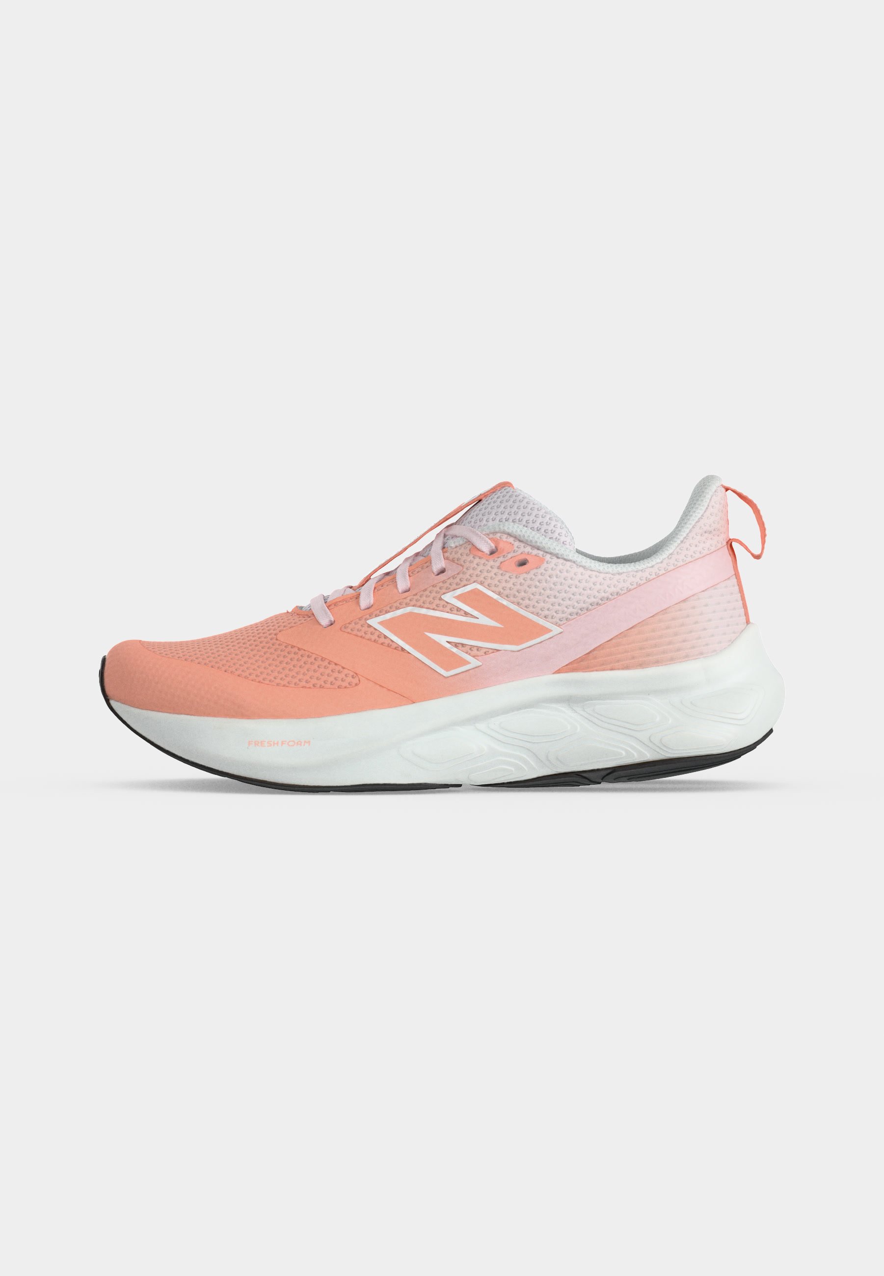 Zapatilla de running New Balance en coral claro y blanco con parte superior de malla, suela acolchada, cordones y lengüeta en el talón.