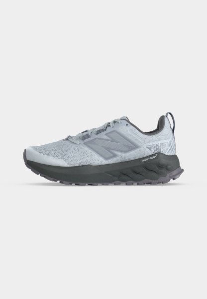 Zapatilla de running New Balance gris claro con suela gruesa gris oscuro y amortiguación "Fresh Foam", logotipo lateral y lengüeta en el talón.