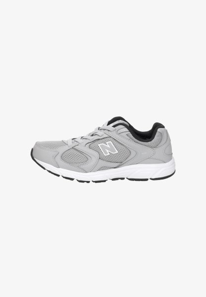 Zapatilla deportiva gris y blanca con paneles de malla, cierre de cordones, suela acolchada y forro interior negro, vista desde el lateral.