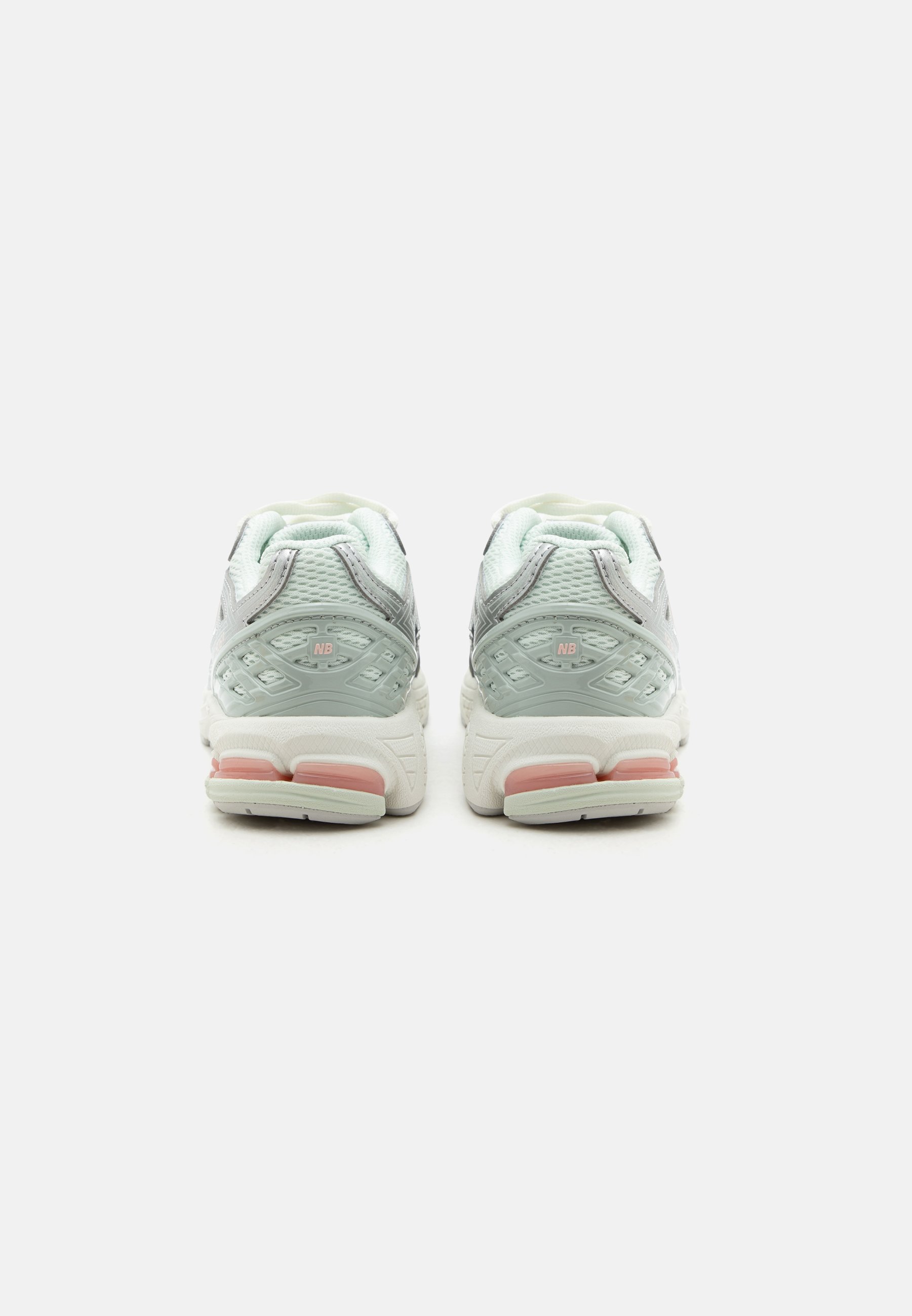 Par de zapatillas deportivas en gris claro y blanco con detalles acolchados rosas, vistas desde atrás sobre un fondo blanco liso.