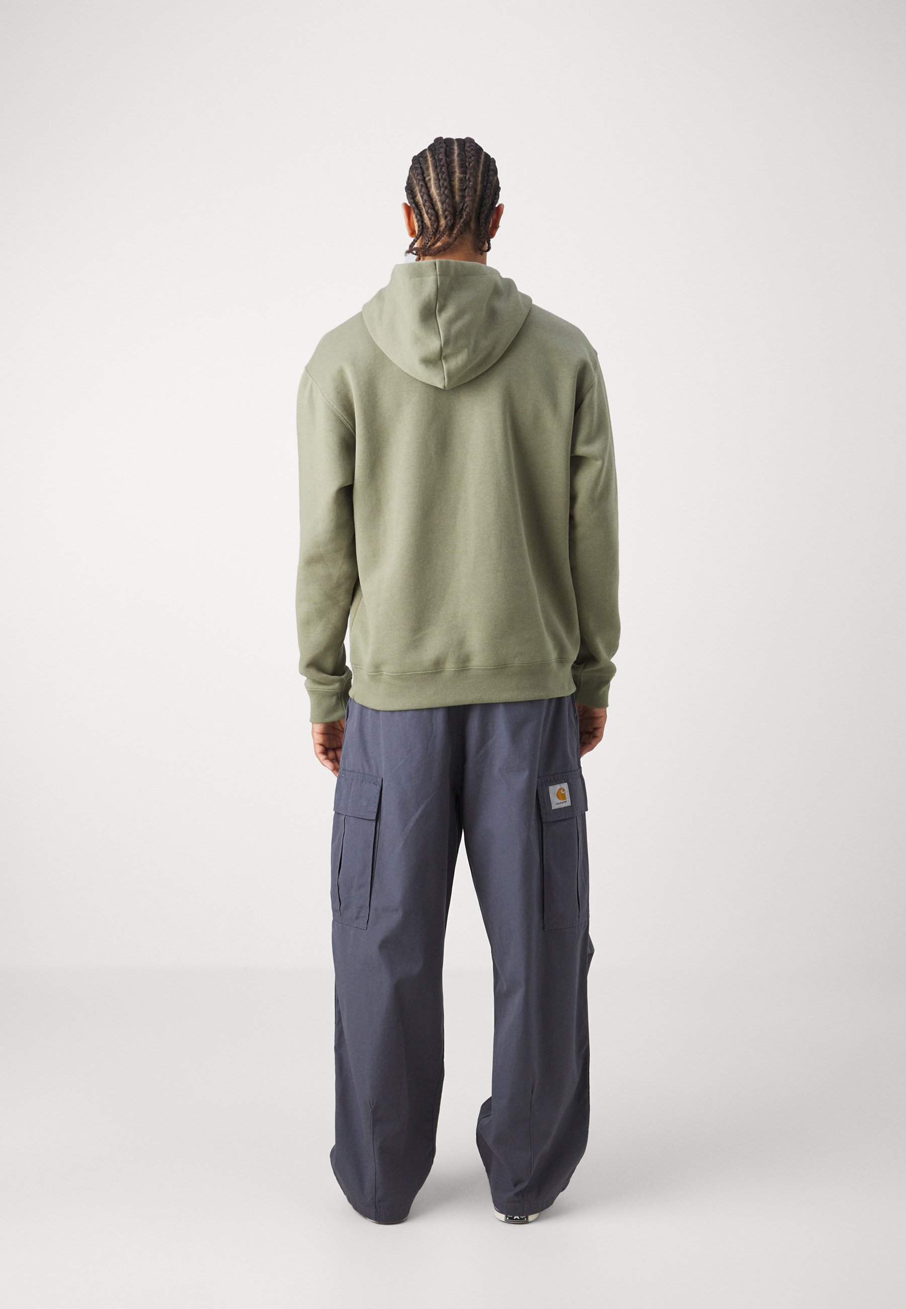 Sudadera con capucha de algodón en verde oliva, combinada con pantalones cargo sueltos en navy que cuentan con bolsillos laterales y un parche con logotipo en el muslo.