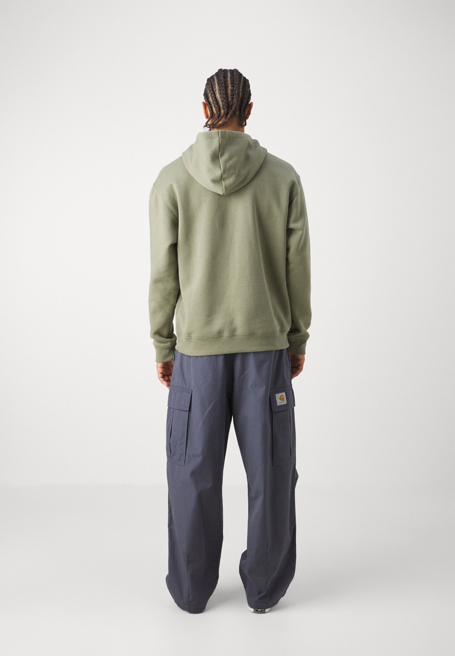 Sudadera con capucha de algodón en verde oliva, combinada con pantalones cargo sueltos en navy que cuentan con bolsillos laterales y un parche con logotipo en el muslo.