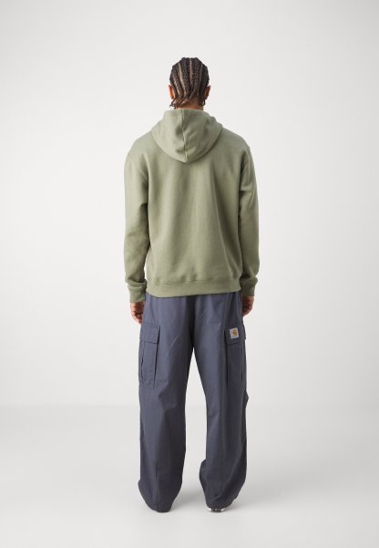 Sudadera con capucha de algodón en verde oliva, combinada con pantalones cargo sueltos en navy que cuentan con bolsillos laterales y un parche con logotipo en el muslo.