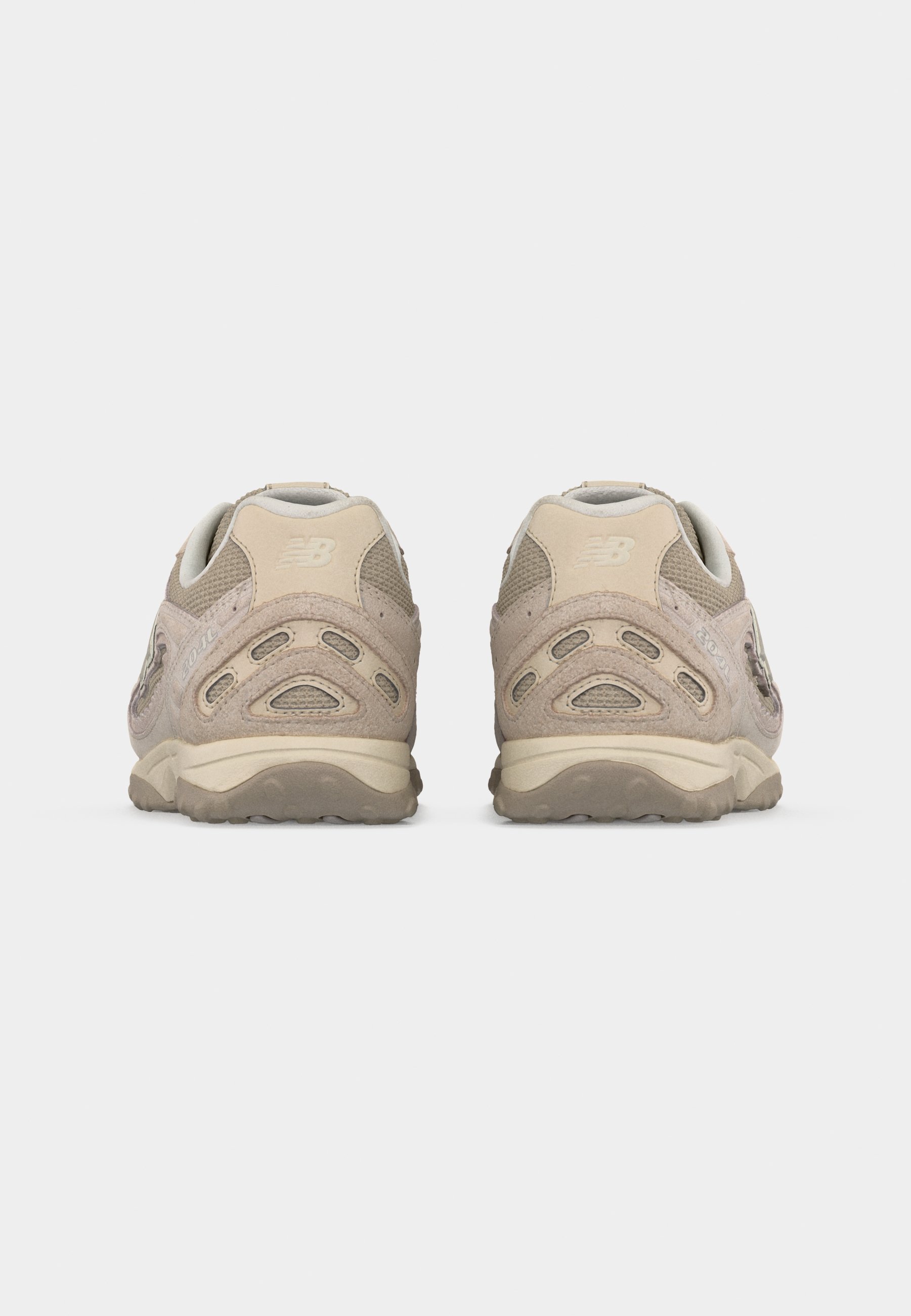Par de zapatillas para correr New Balance en tonos beige y marrón claro, mostradas desde atrás sobre un fondo blanco.