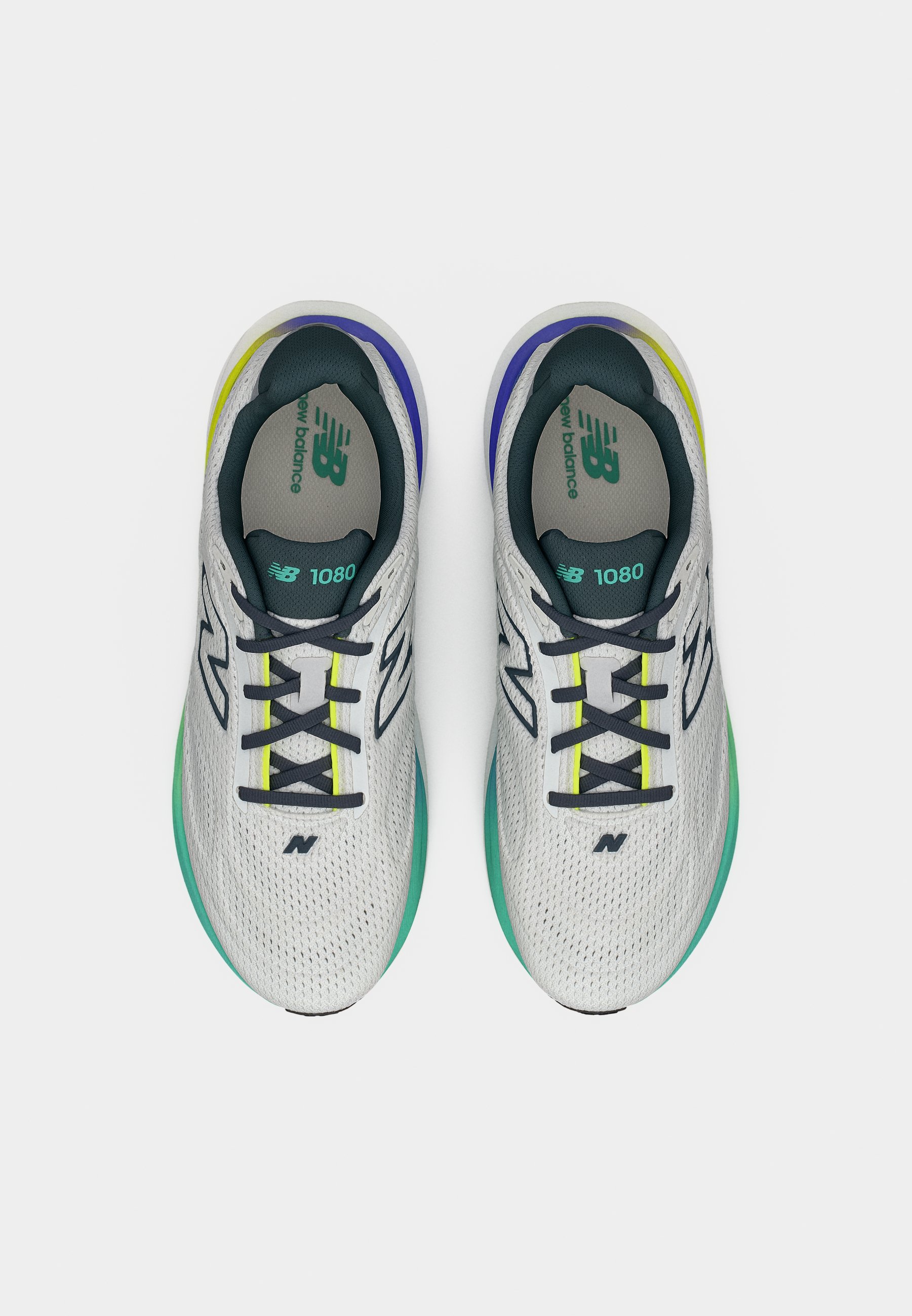 Par de zapatillas de running New Balance 1080 blancas con cordones negros y detalles en verde, azul y amarillo, vistas desde arriba sobre un fondo blanco.