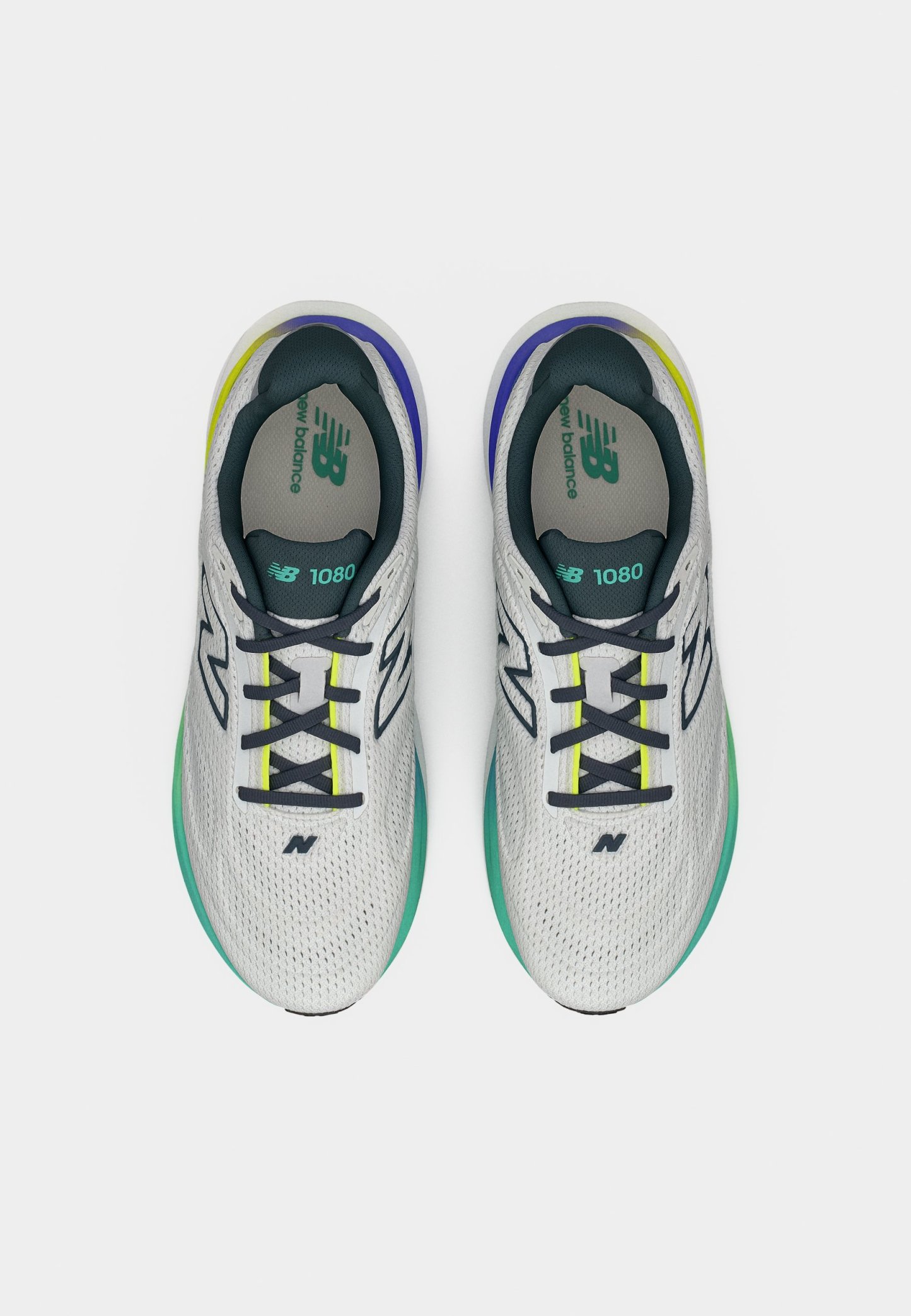 Par de zapatillas de running New Balance 1080 blancas con cordones negros y detalles en verde, azul y amarillo, vistas desde arriba sobre un fondo blanco.