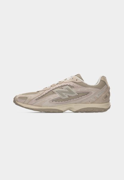 Zapatilla deportiva New Balance 2040 en beige y topo con parte superior de malla y ante, suela de goma y logo "N" en el lateral izquierdo.