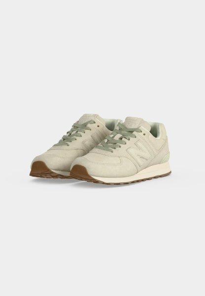 Par de zapatillas de ante beige con cordones verdes y suelas de goma marrones sobre fondo blanco.