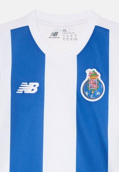 Camiseta de fútbol blanca y azul a rayas con el logo de New Balance a la izquierda y el escudo del FC Porto en el pecho derecho.