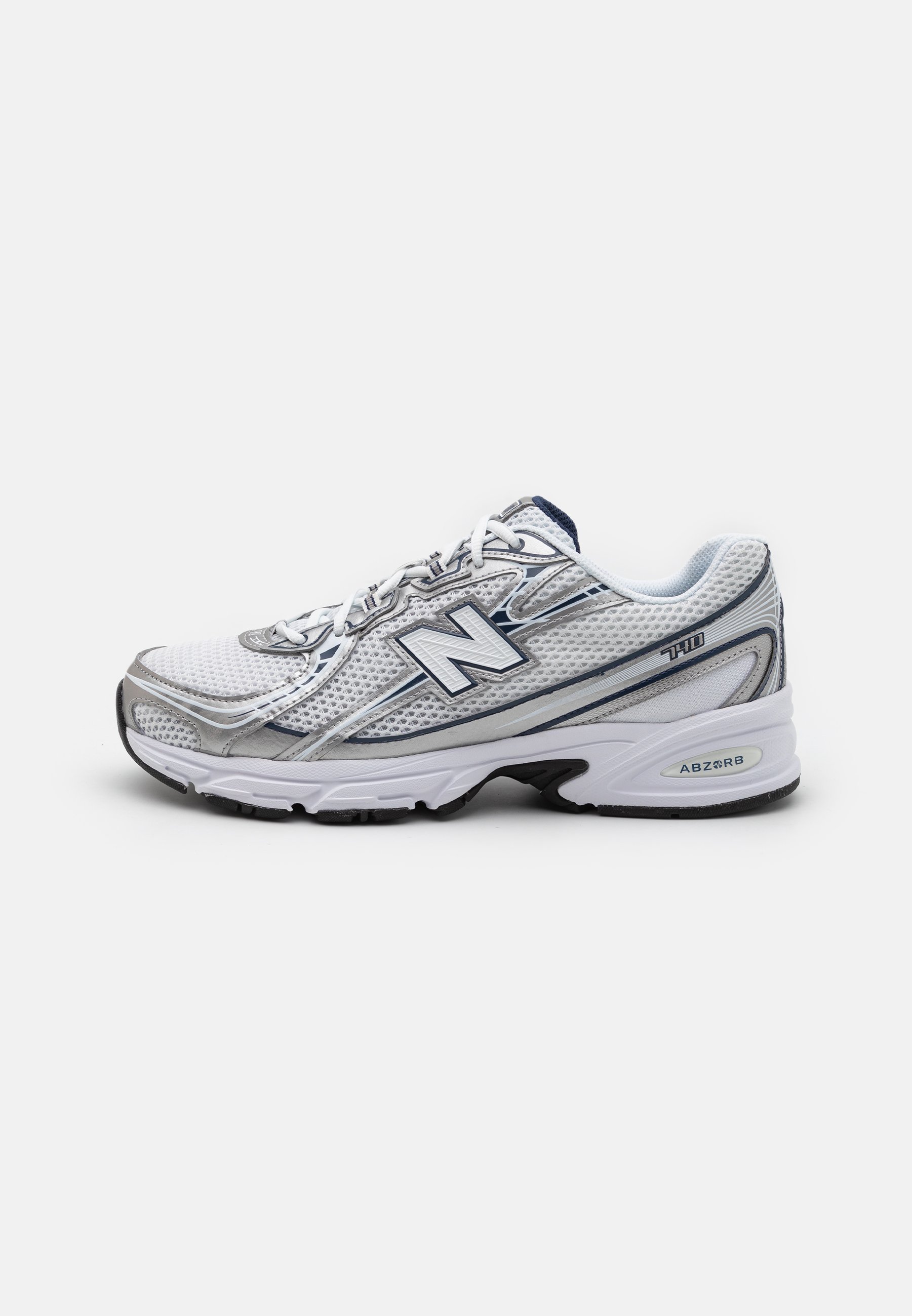 Zapatilla deportiva New Balance con parte superior de malla, predominantemente blanca con acentos en gris y azul marino, que presenta una suela acolchada y detalles texturizados.