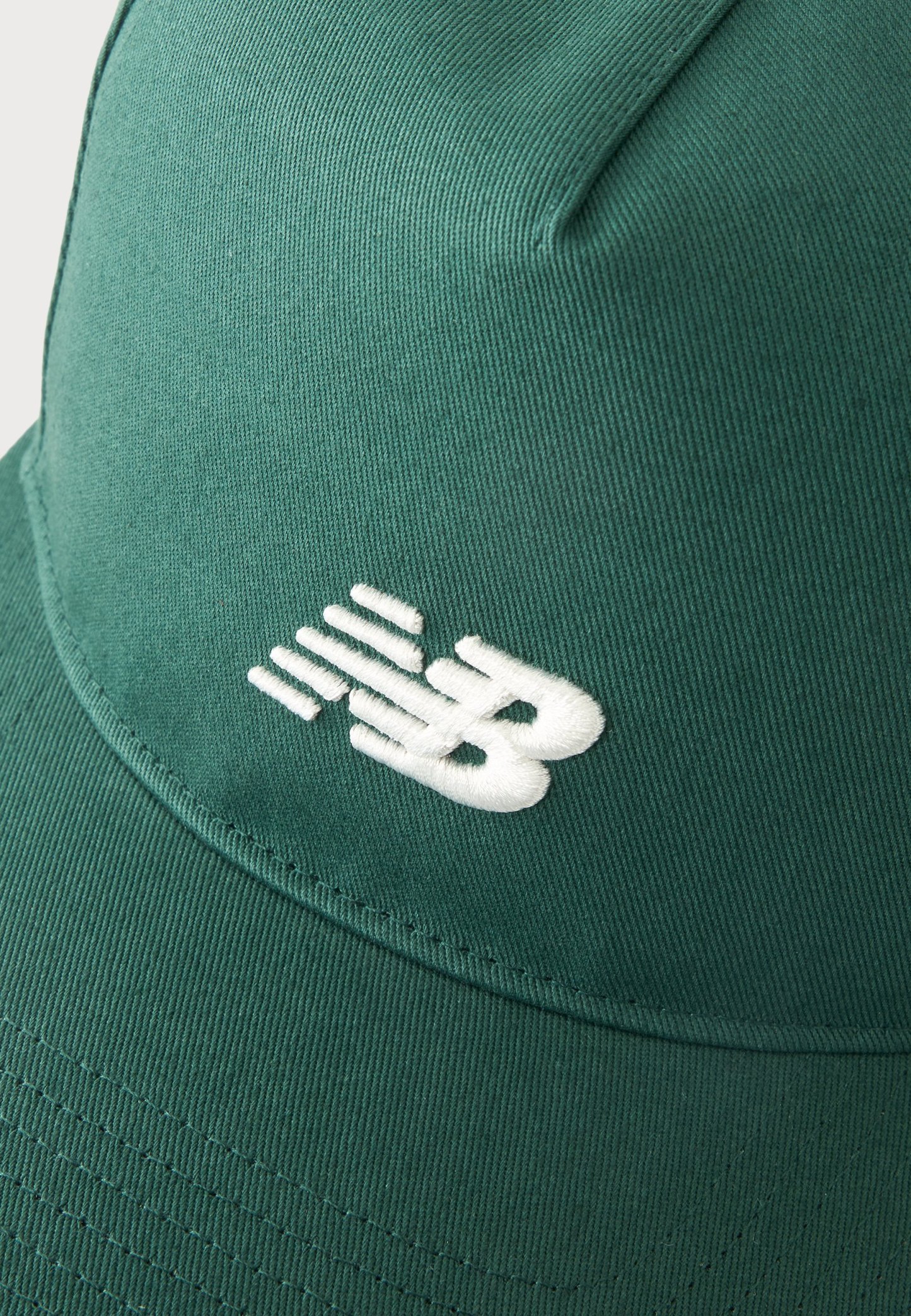 Gorra de béisbol de tela verde con el logotipo de New Balance bordado en blanco en el panel frontal.