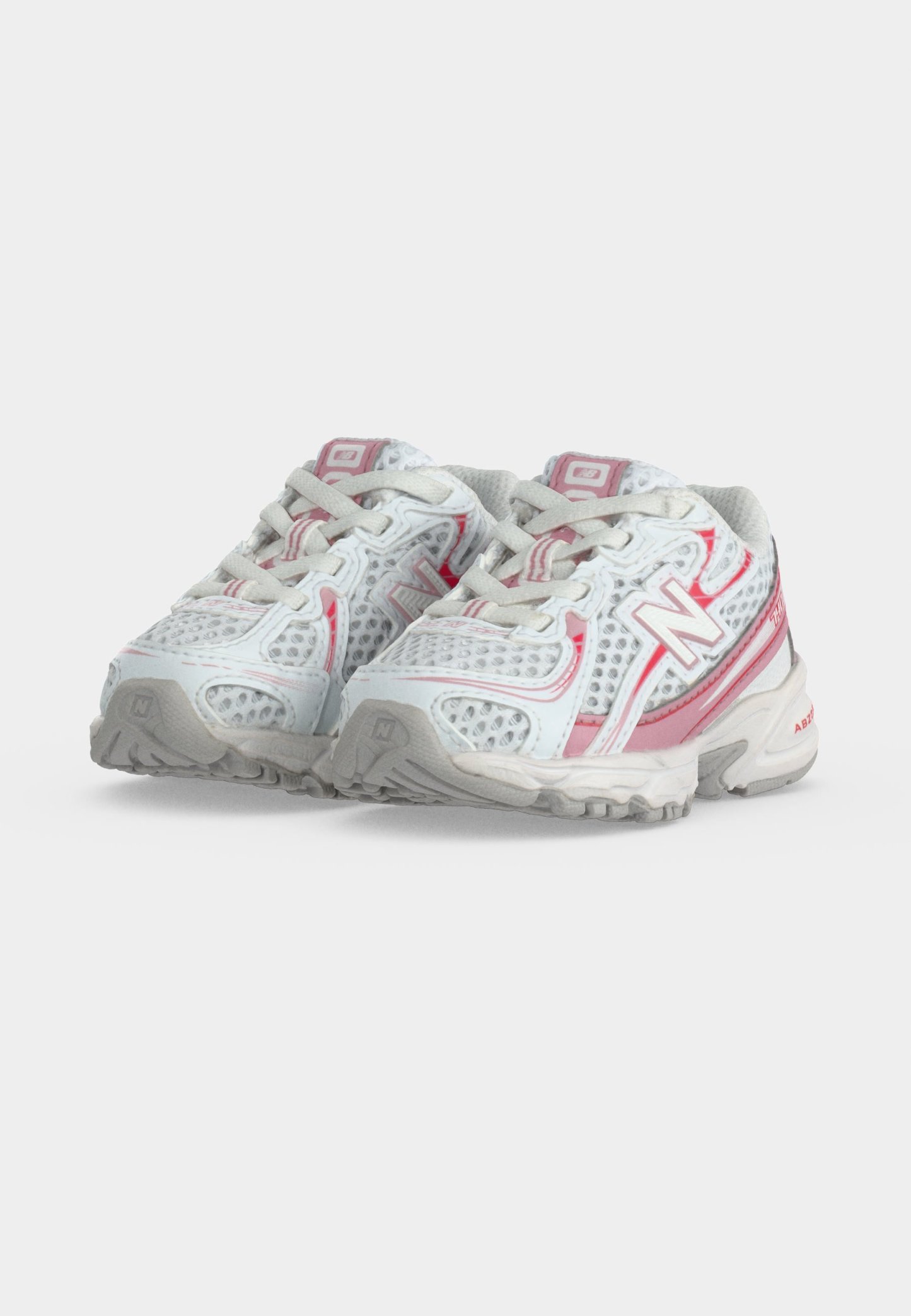 Par de zapatillas deportivas New Balance blancas y rosas con paneles de malla y cordones, colocadas una al lado de la otra sobre un fondo simple.