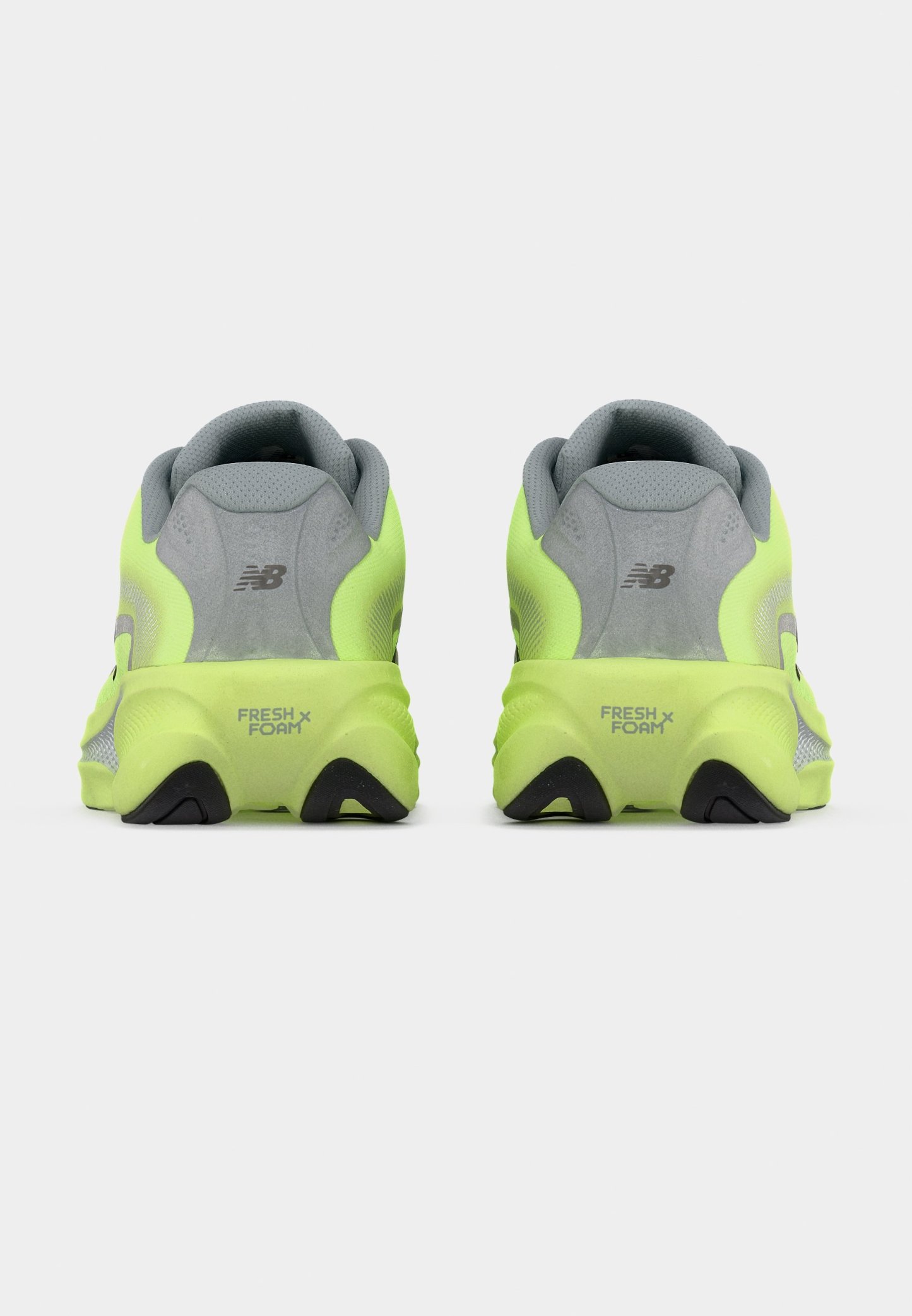 Zapatillas de correr de color amarillo neón con parte superior de malla gris, collarín acolchado en el talón y suela de goma negra con la marca "FRESH FOAM" en el talón.