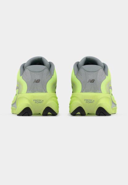 Zapatillas de correr de color amarillo neón con parte superior de malla gris, collarín acolchado en el talón y suela de goma negra con la marca "FRESH FOAM" en el talón.