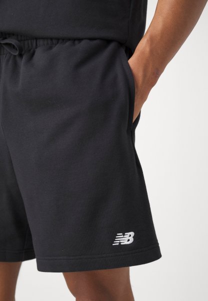 Shorts de algodón negros con cintura elástica, que cuentan con bolsillos laterales y un logo bordado en blanco 'NB' en la parte inferior de la pierna izquierda.