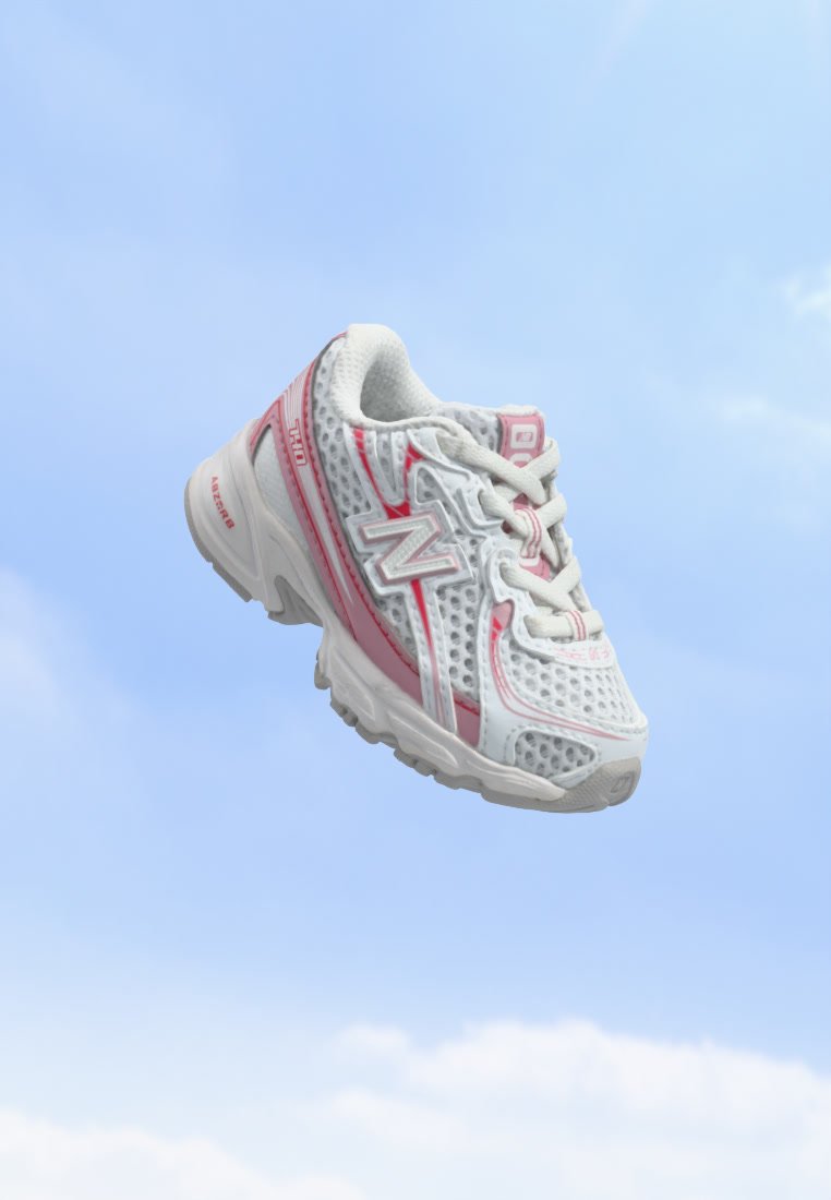 Zapatilla de running New Balance blanca y rosa con detalles de malla flotando sobre un fondo de cielo azul.