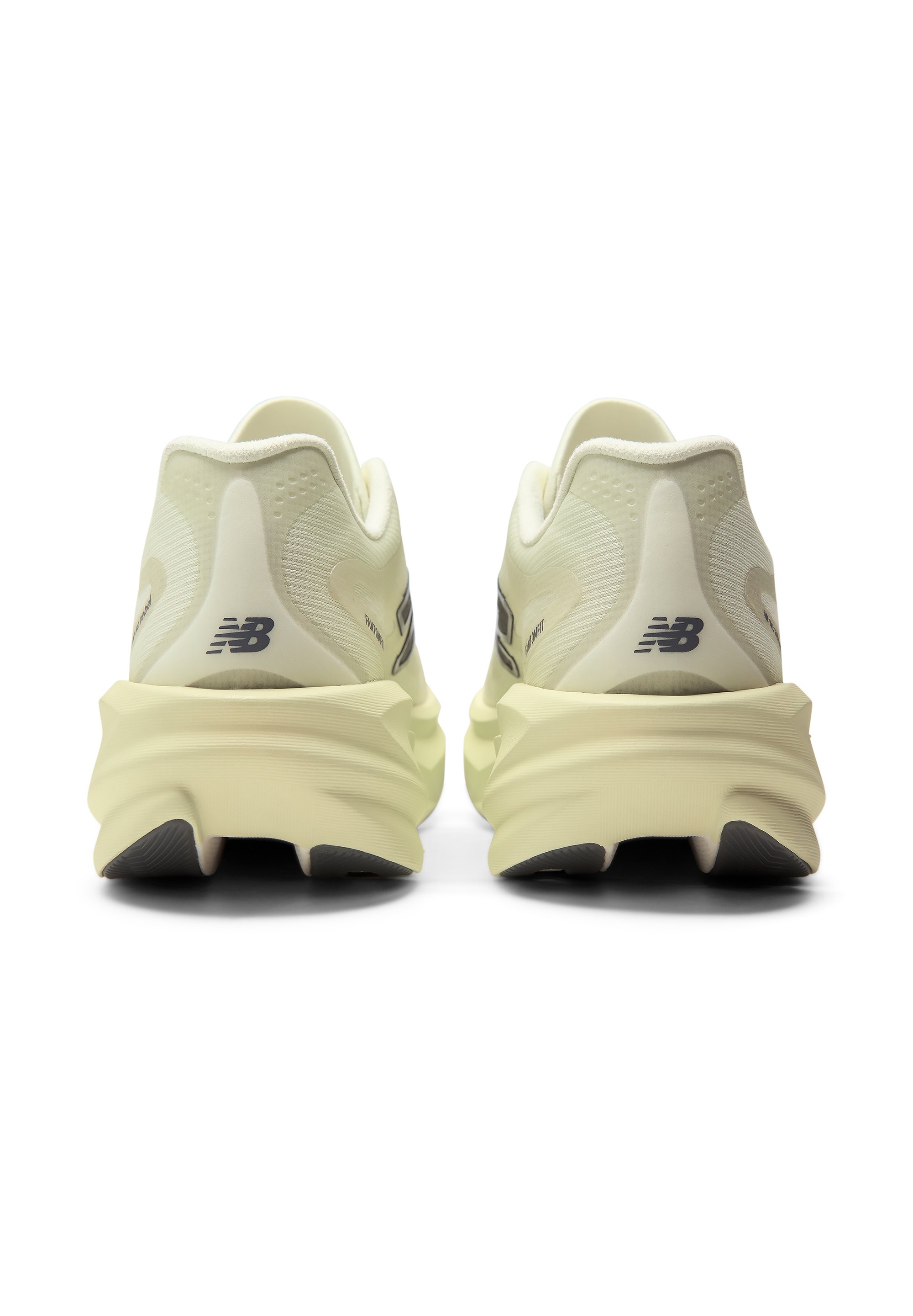 Par de zapatillas de correr New Balance beige vistas desde atrás con suelas gruesas y texturizadas y pequeños logos negros en los talones.