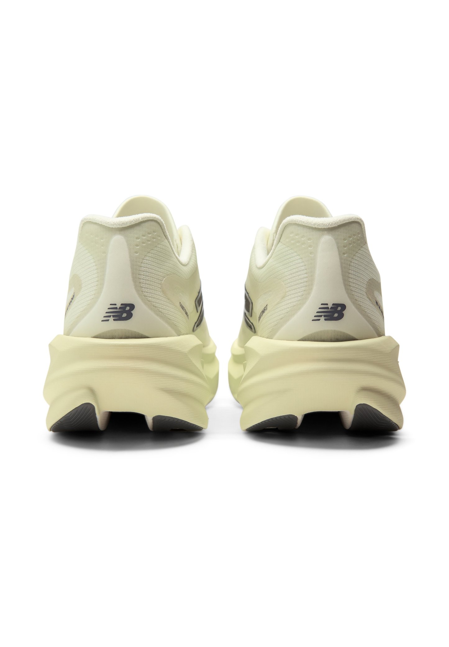 Par de zapatillas de correr New Balance beige vistas desde atrás con suelas gruesas y texturizadas y pequeños logos negros en los talones.