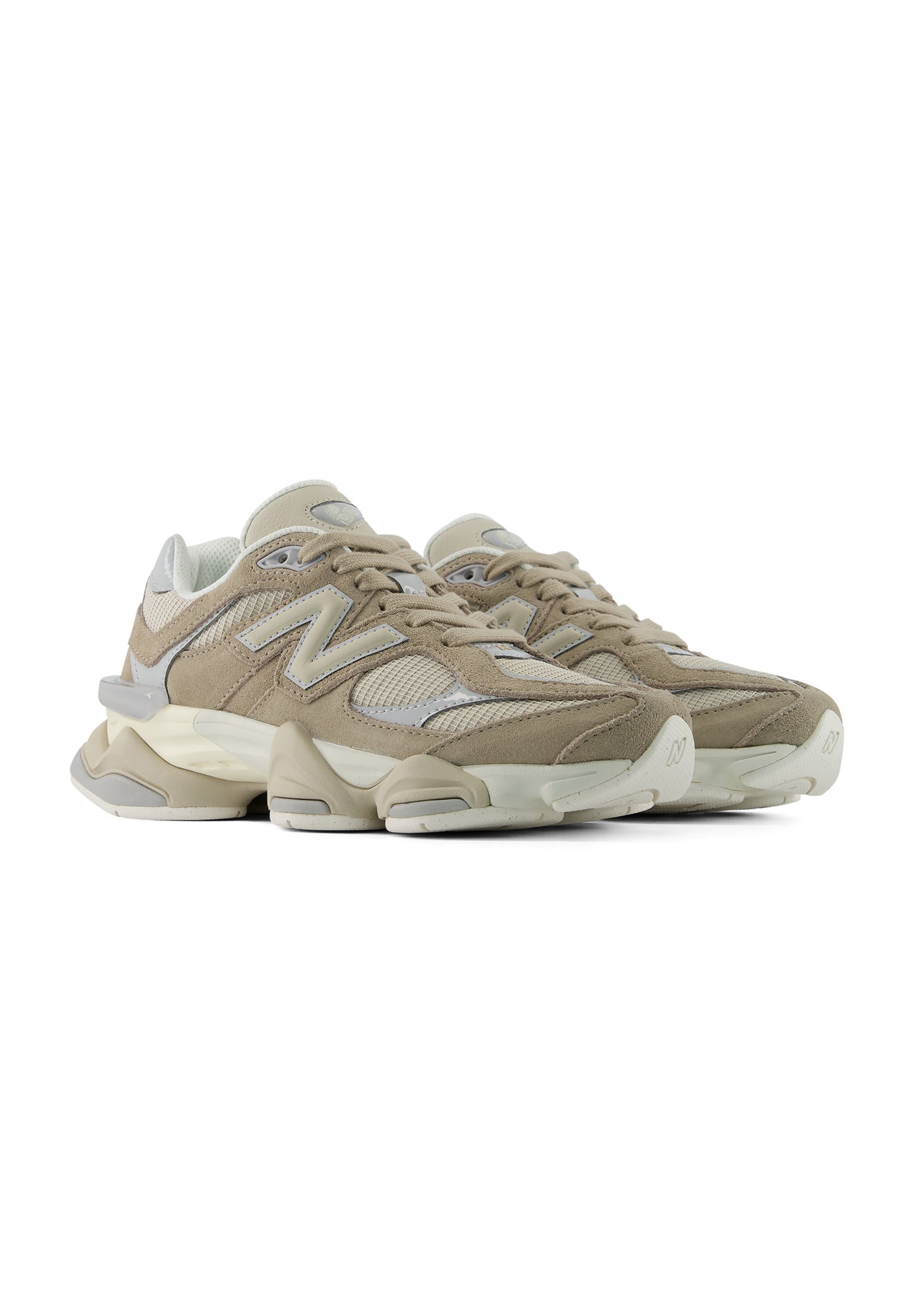 Par de zapatillas deportivas beige y blancas con detalles de malla y ante y suelas acolchadas gruesas sobre fondo blanco.