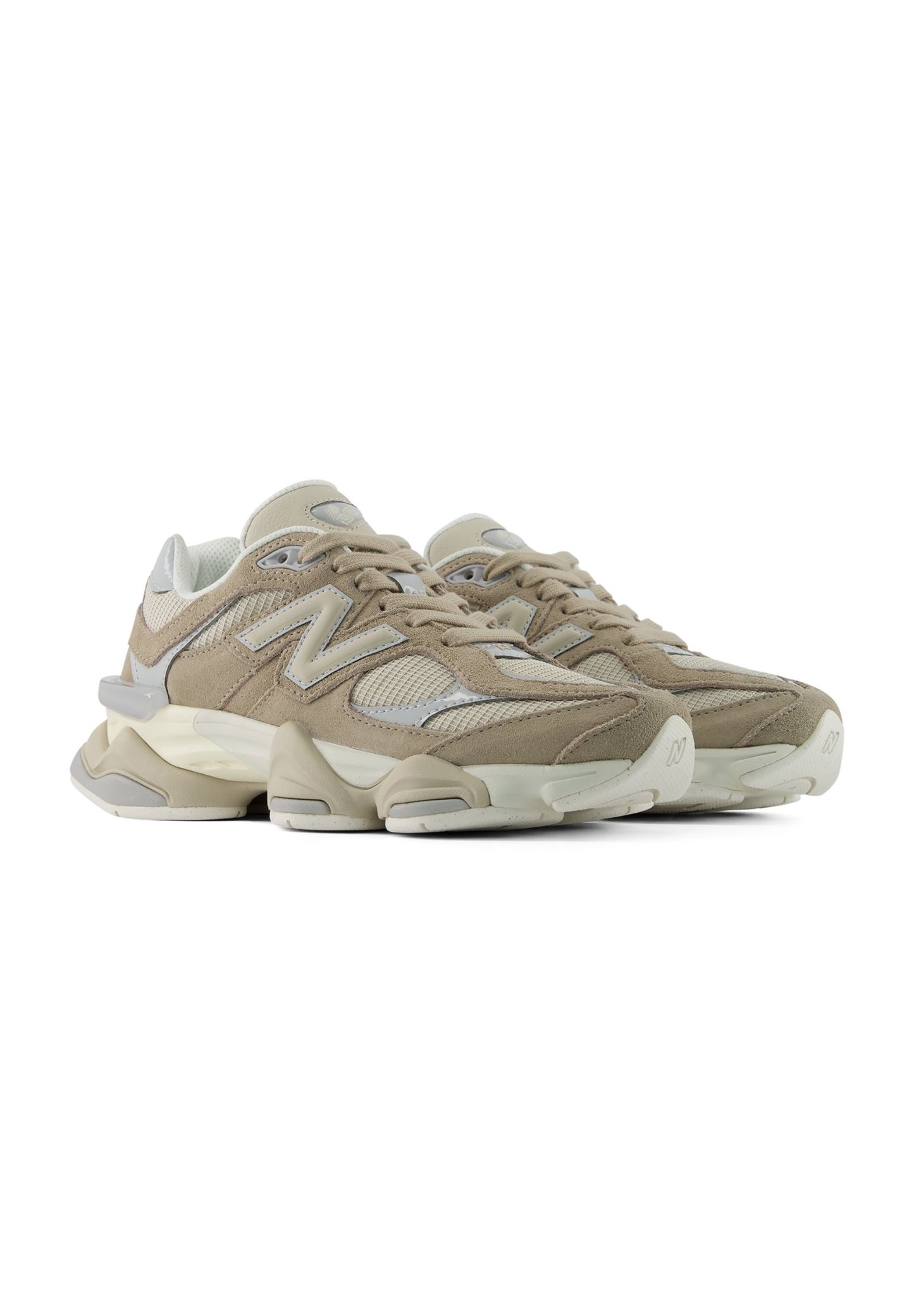Par de zapatillas deportivas beige y blancas con detalles de malla y ante y suelas acolchadas gruesas sobre fondo blanco.