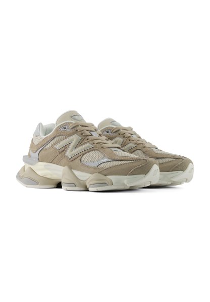 Par de zapatillas deportivas beige y blancas con detalles de malla y ante y suelas acolchadas gruesas sobre fondo blanco.