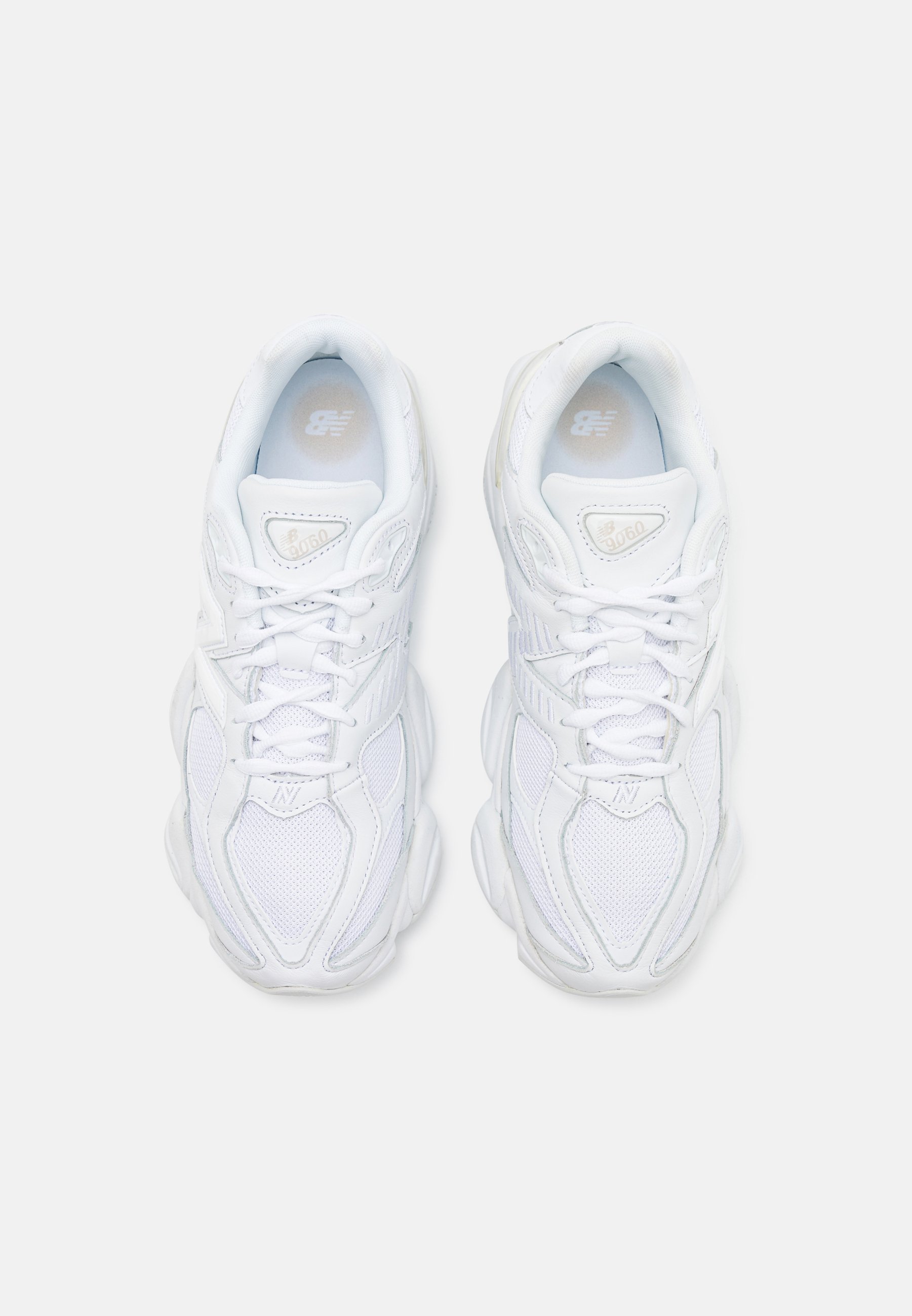 Zapatillas blancas con un upper de malla texturizada, suela acolchada y cordones. Presenta un logotipo discreto en la lengüeta y en el lateral.