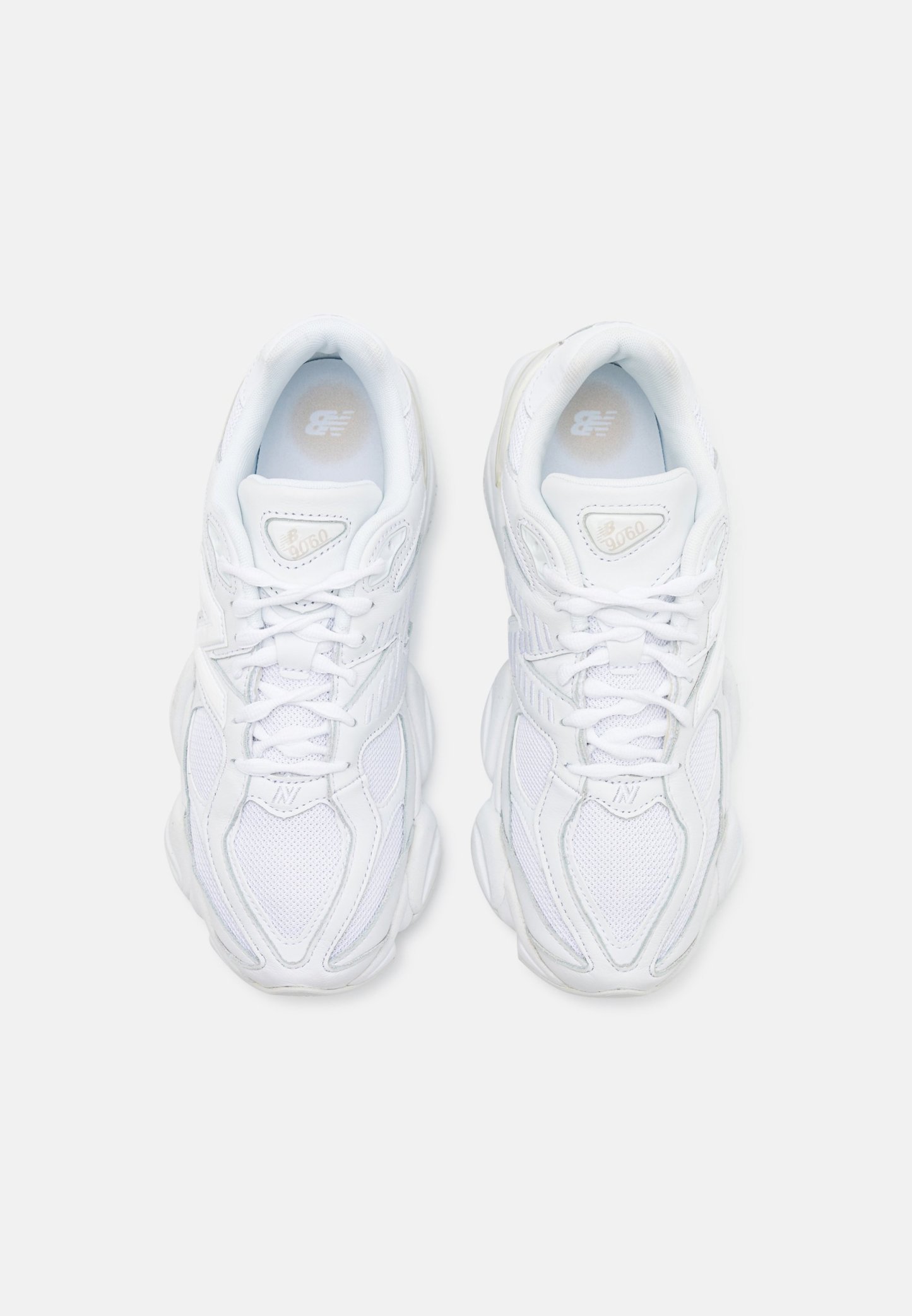 Zapatillas blancas con un upper de malla texturizada, suela acolchada y cordones. Presenta un logotipo discreto en la lengüeta y en el lateral.